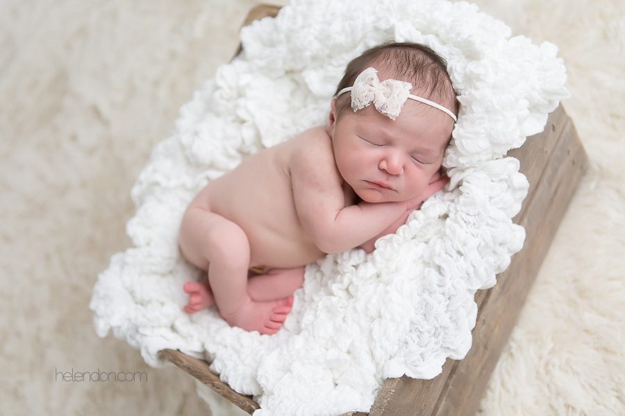 newborn girl sleeping on white blanket