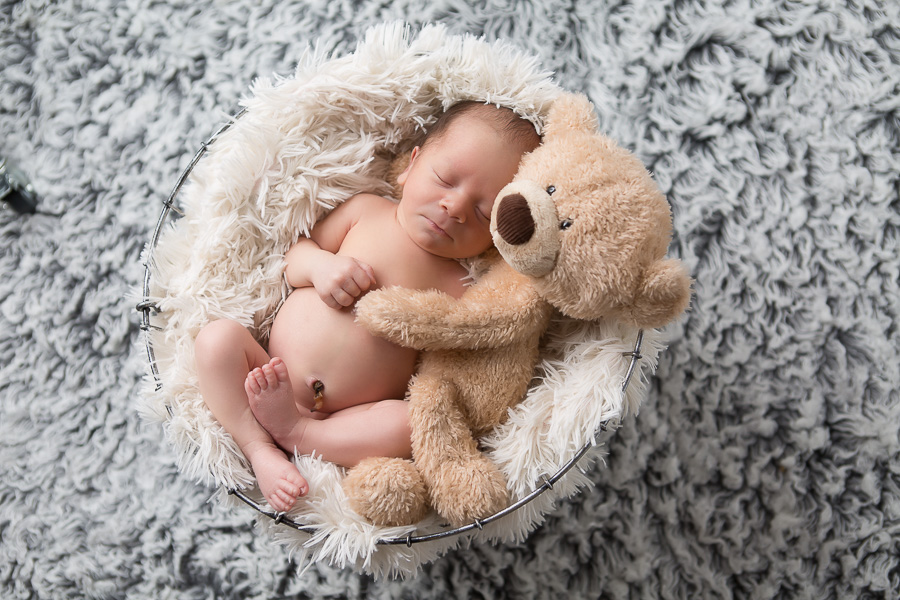 newborn boy sleeping with teddy bear