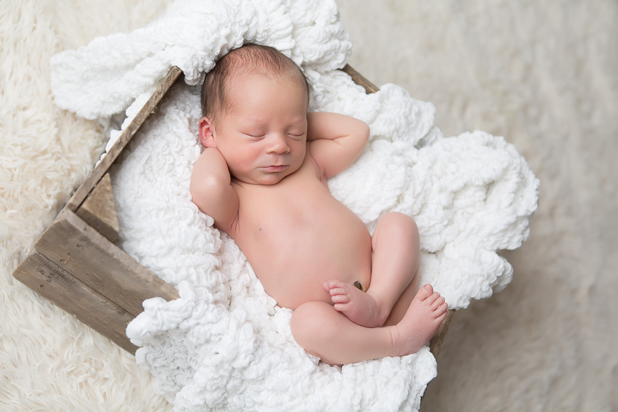 newborn asleep with hands behind head