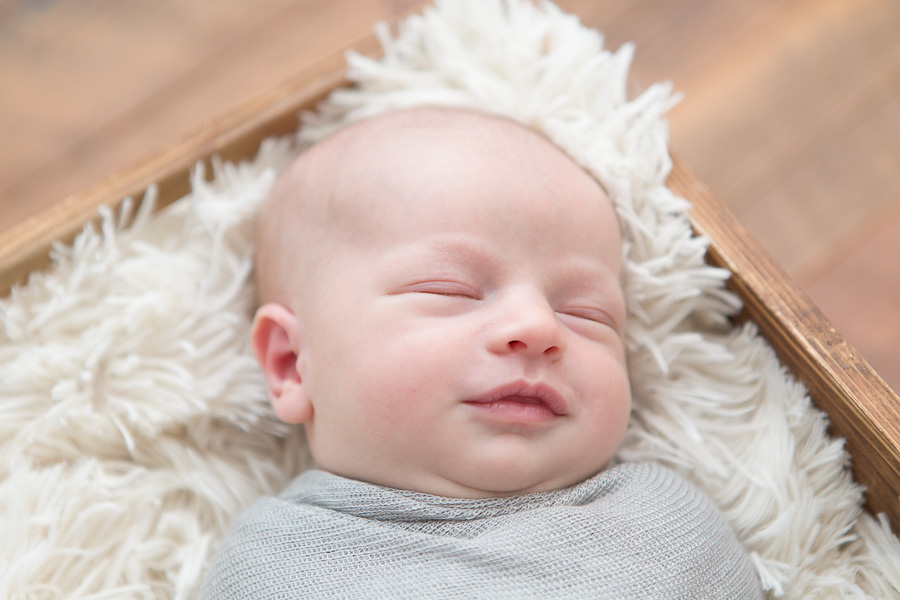 swaddled newborn smiling