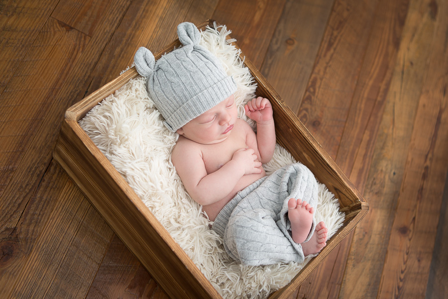 newborn boy sleeping in wooden crate