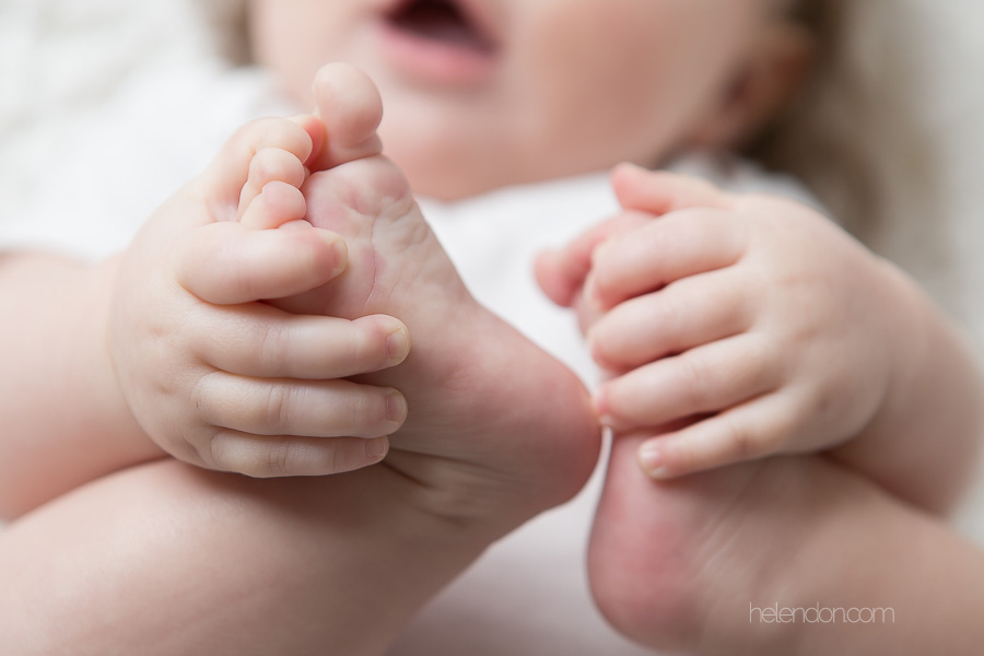 close up of baby grabbing toes in hands
