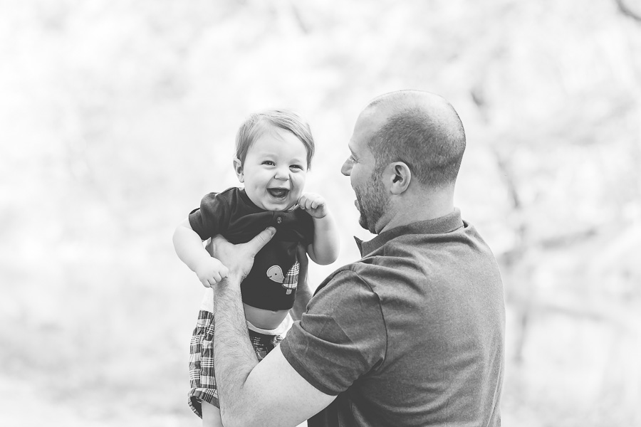 b&w of dad holding laughing baby boy
