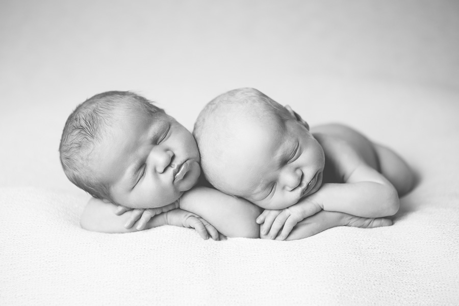 black and white photo of newborn twins sleeping side by side