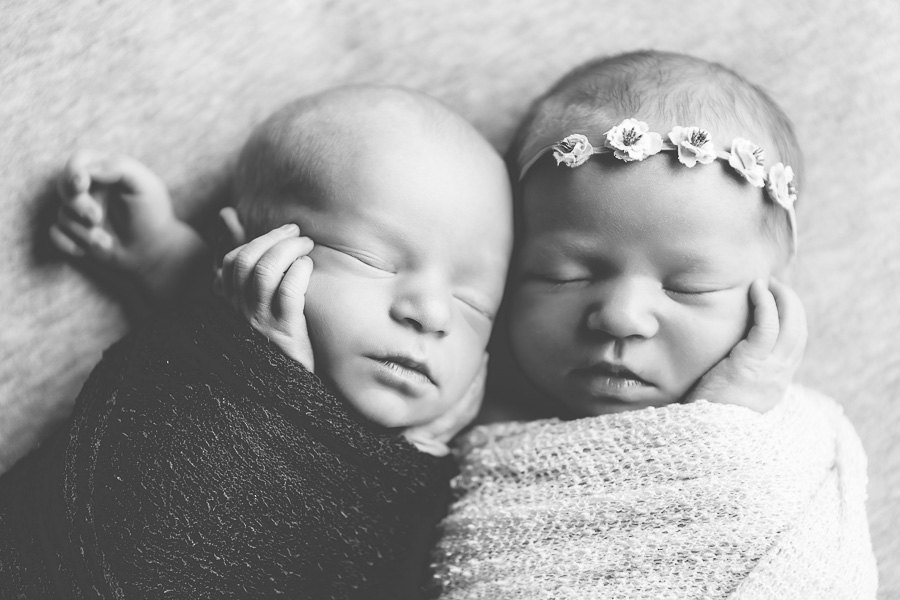 newborn twins sleeping together black & white image
