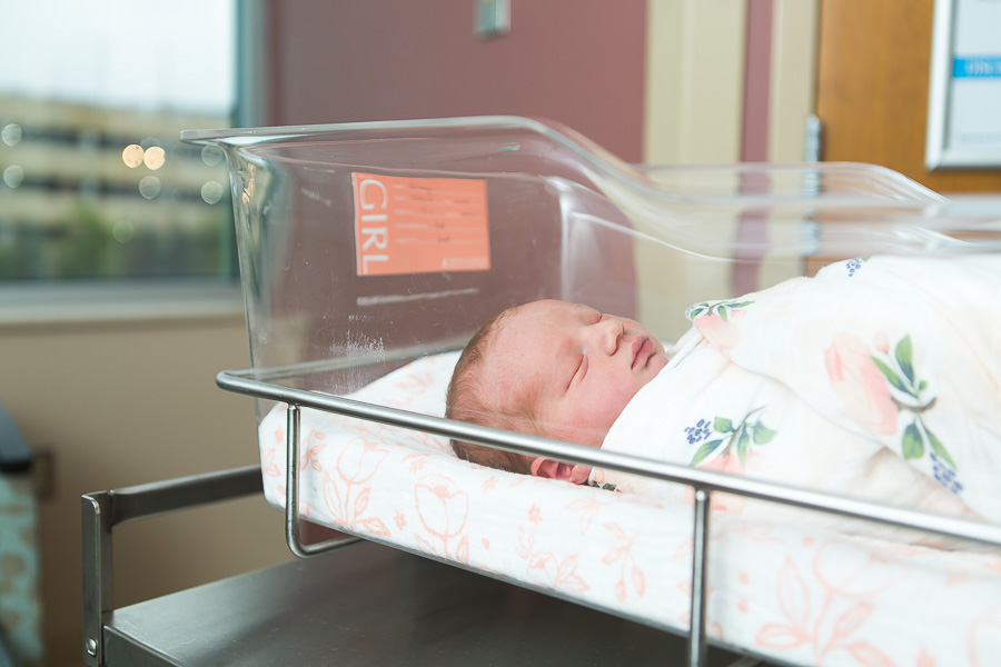 newborn baby girl sleeping in bassinet at hospital