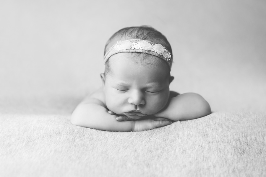 black and white portrait of newborn girl head on hands