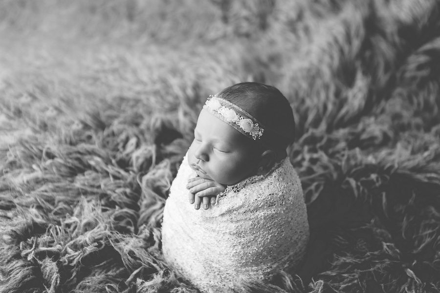 black and white photo of newborn girl swaddled