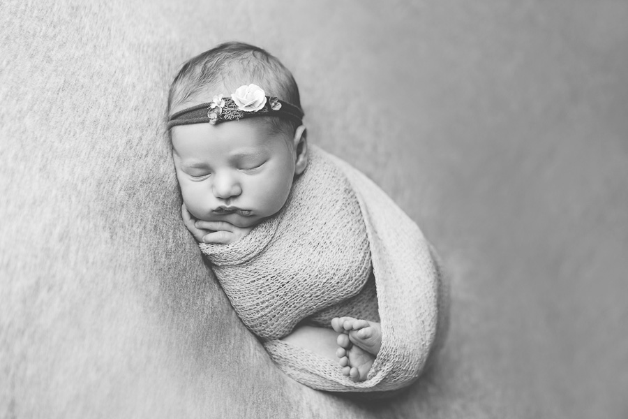 newborn wrapped and sleeping black and white image