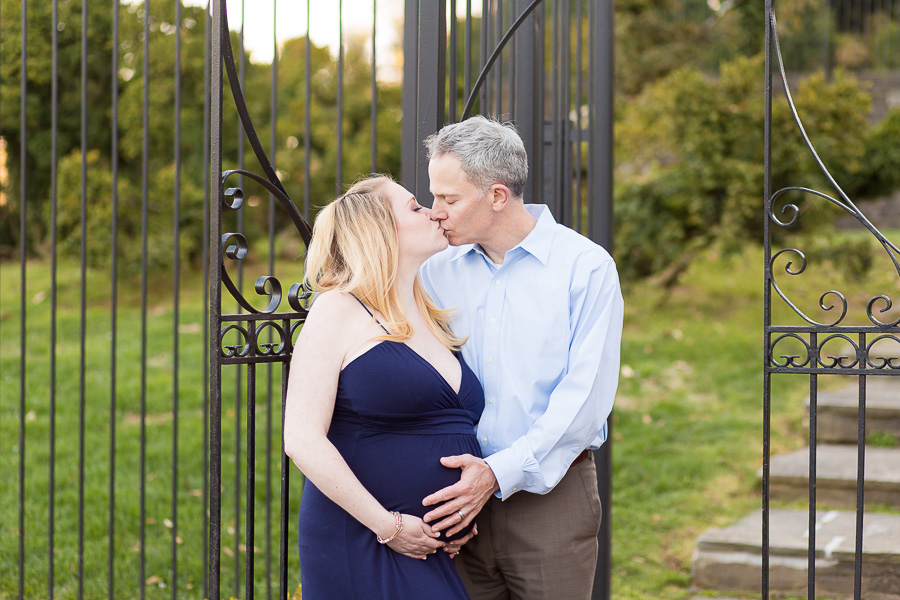 expecting parents holding belly kissing