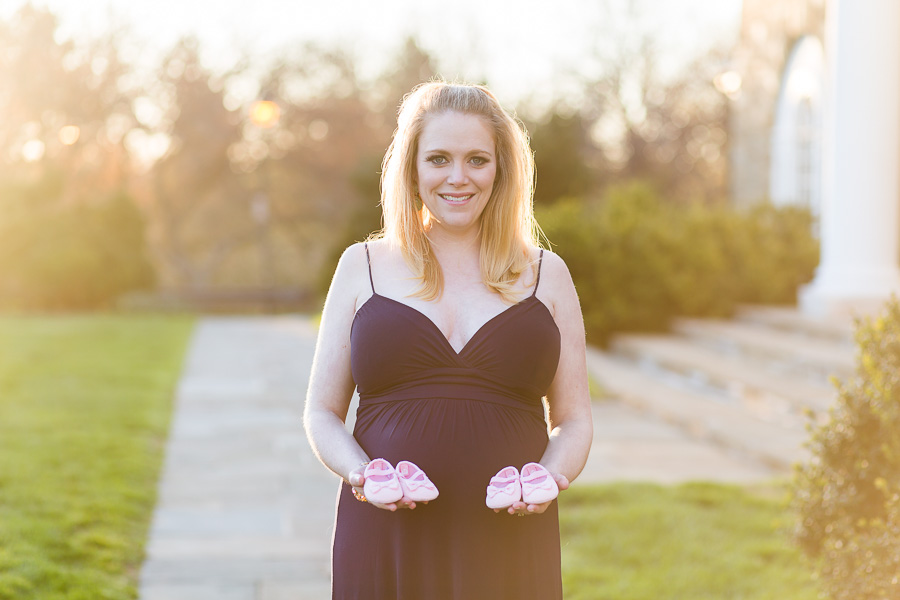 soon-to-be-mom holding two pairs of pink shoes