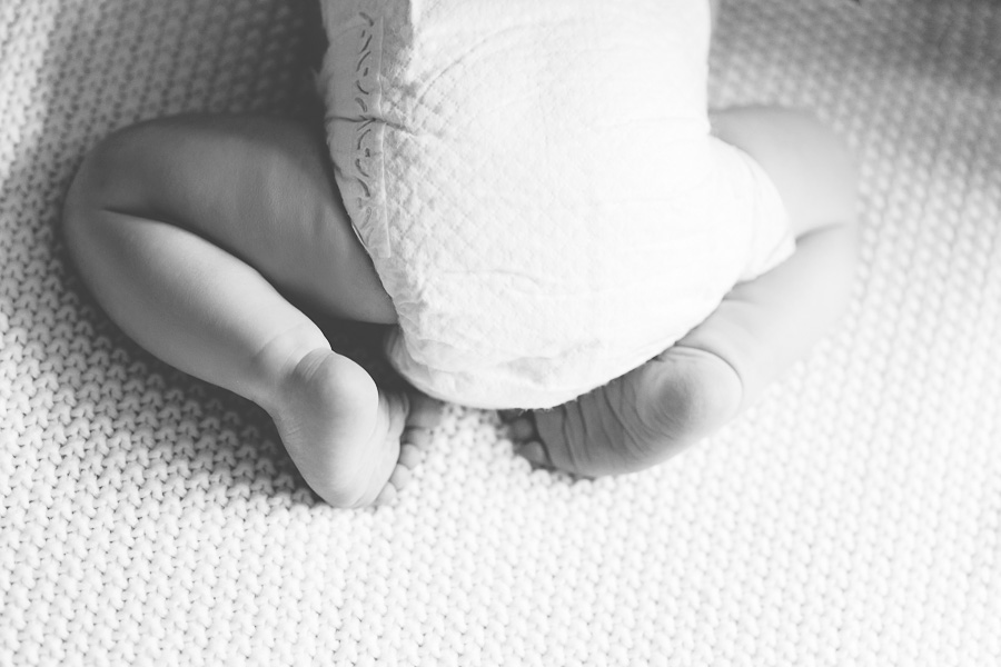 black and white of newborn boy feet curled up