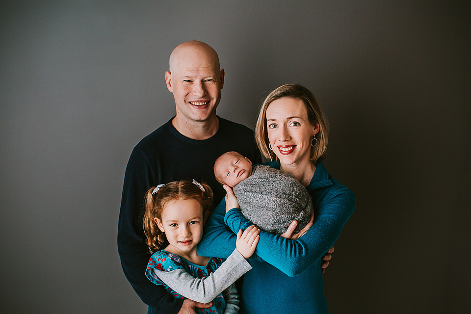family posing with newborn baby boy